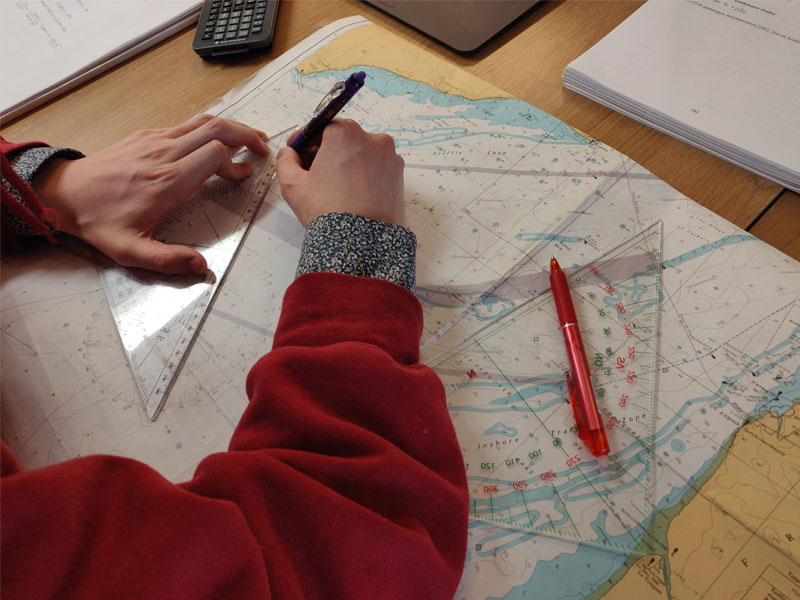 Sjökort. Linjaler. Studenten Peter Lundmark pluggar hemifrån.