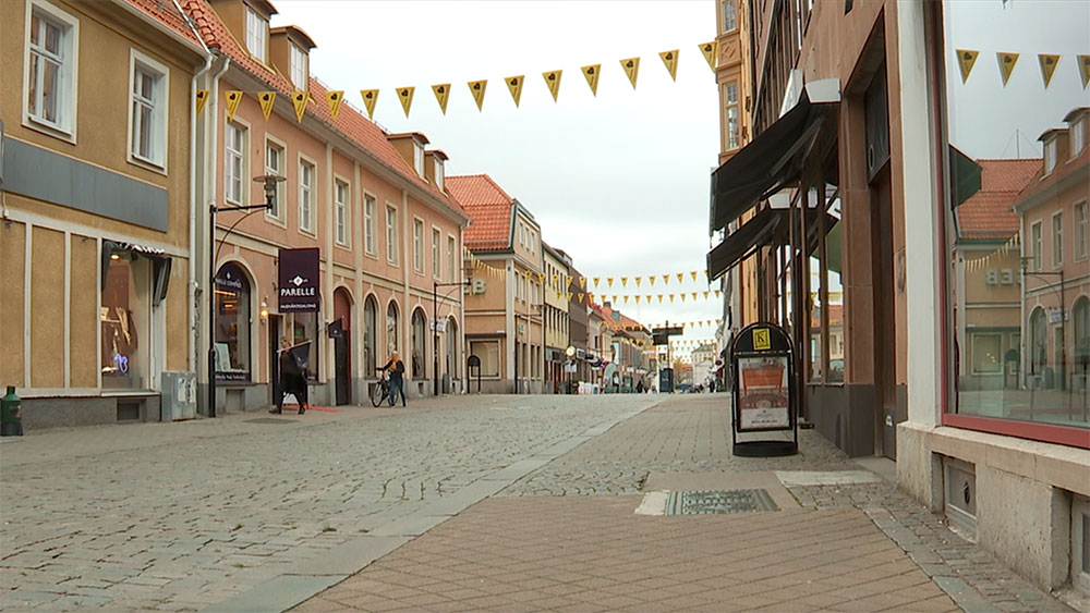 Två handlare går på gatorna mellan butikerna på Kvarnholmen.
