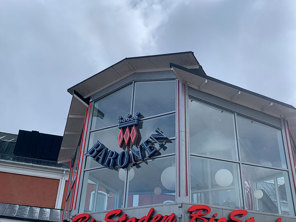 Bild på ingången till köpcentrumet Baronen i Kalmar. Endast Baronens logga ovanför ingången syns i bild och ovanför ser man himlen.