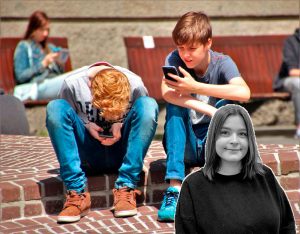 Bild på två pojkar som sitter ner och håller i varsin mobiltelefon. Elsas krönikabild syns i hörnet.