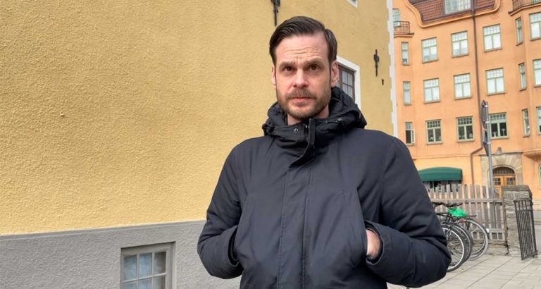 Marcus Jäverskog står utanför Kalmar trafikskola. Han har en svart jacka på sig. Huset bakom honom är gult.