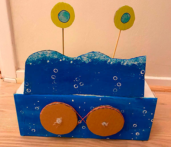 Bild på Filippas konstruktion som ska föreställa urcellens delning. I denna bild ser man när cellen har delats i två. Hon har skapat sin konstruktion av en skolåda.