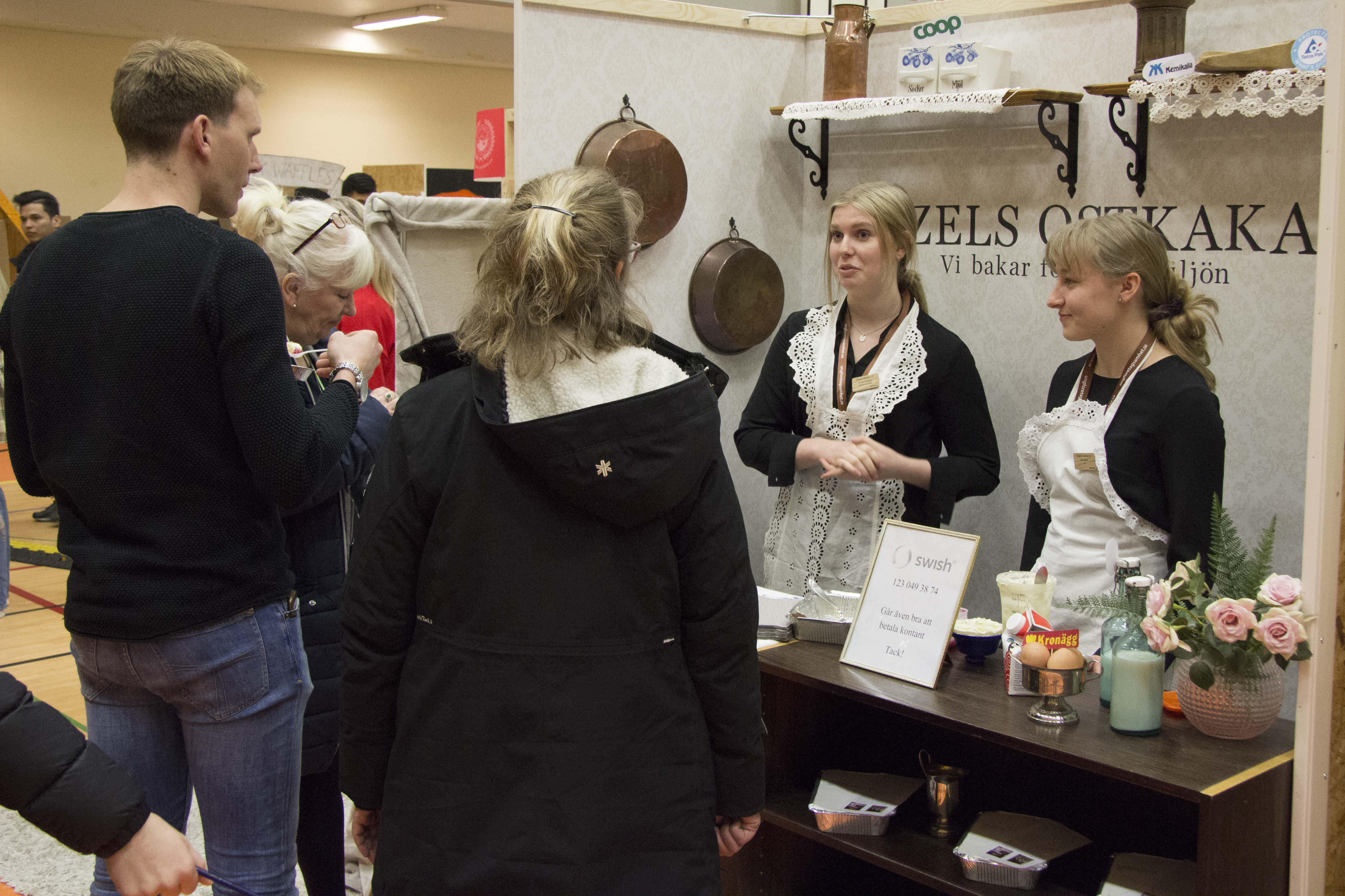 Två elever pratar om sina varor för tre potentiella kunder.