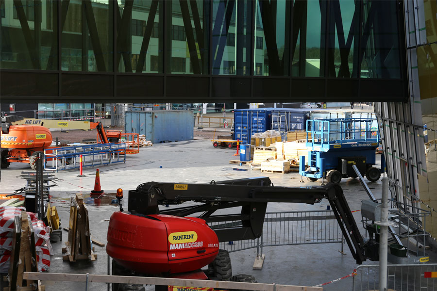 Lyftkranar, containrar och en lift under gångbron mellan husen Stella och Culmen.