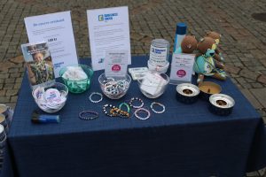 Barncancerfondens bord utsmyckat med bland annat pärlband och informationsblad.
