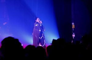 Miriam Bryant på scen och publiken står och lyssnar.