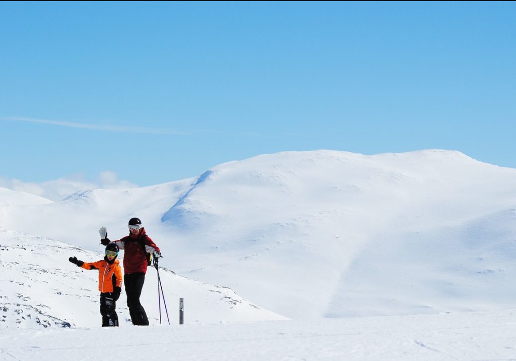 Två personer står och poserar i skidkläder i backen