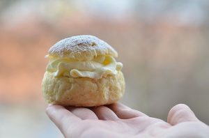 En hand som håller i en liten semla