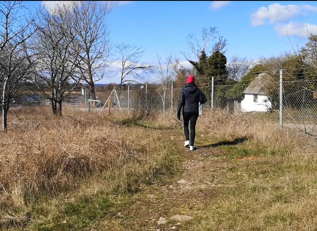 En bild på när en kvinna promenerar på en stig.