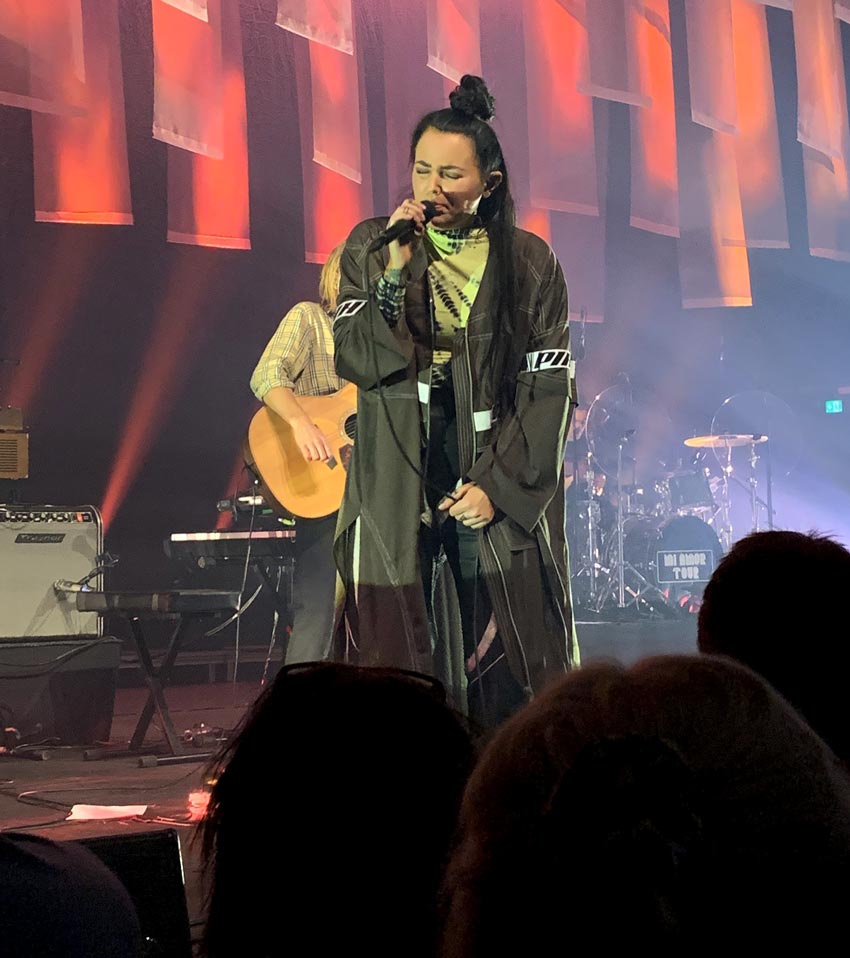 Miriam står på scen och sjunger för publiken.