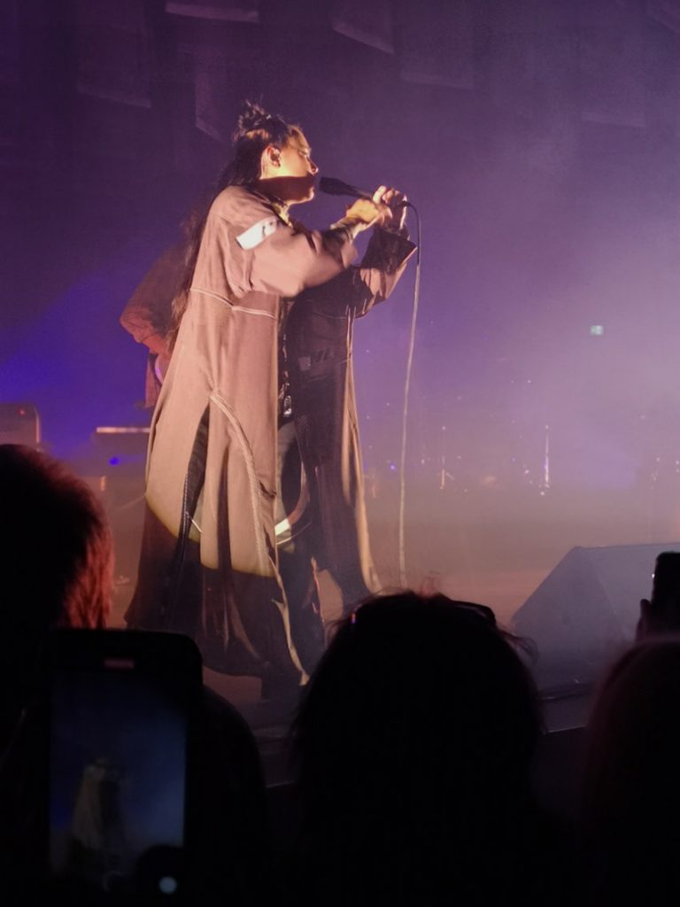 Miriam står på scen och håller i mikrofonen.