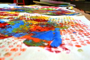 En färgglad målning som ett av barnen gjort med hjälp av olika trycktekniker
