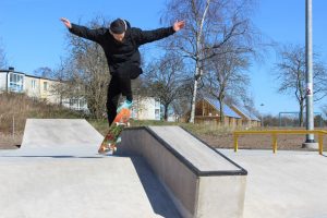 hoppar med sin skateboard