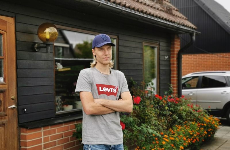 Emil står med armarna i kors utanför sitt hus.