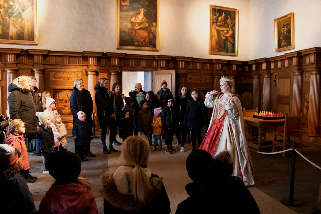 Prinsessan Cecilia berättar för en grupp barn om drottningen.