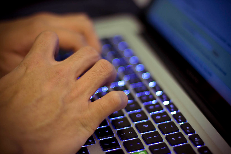 Händer arbetar på en dator.