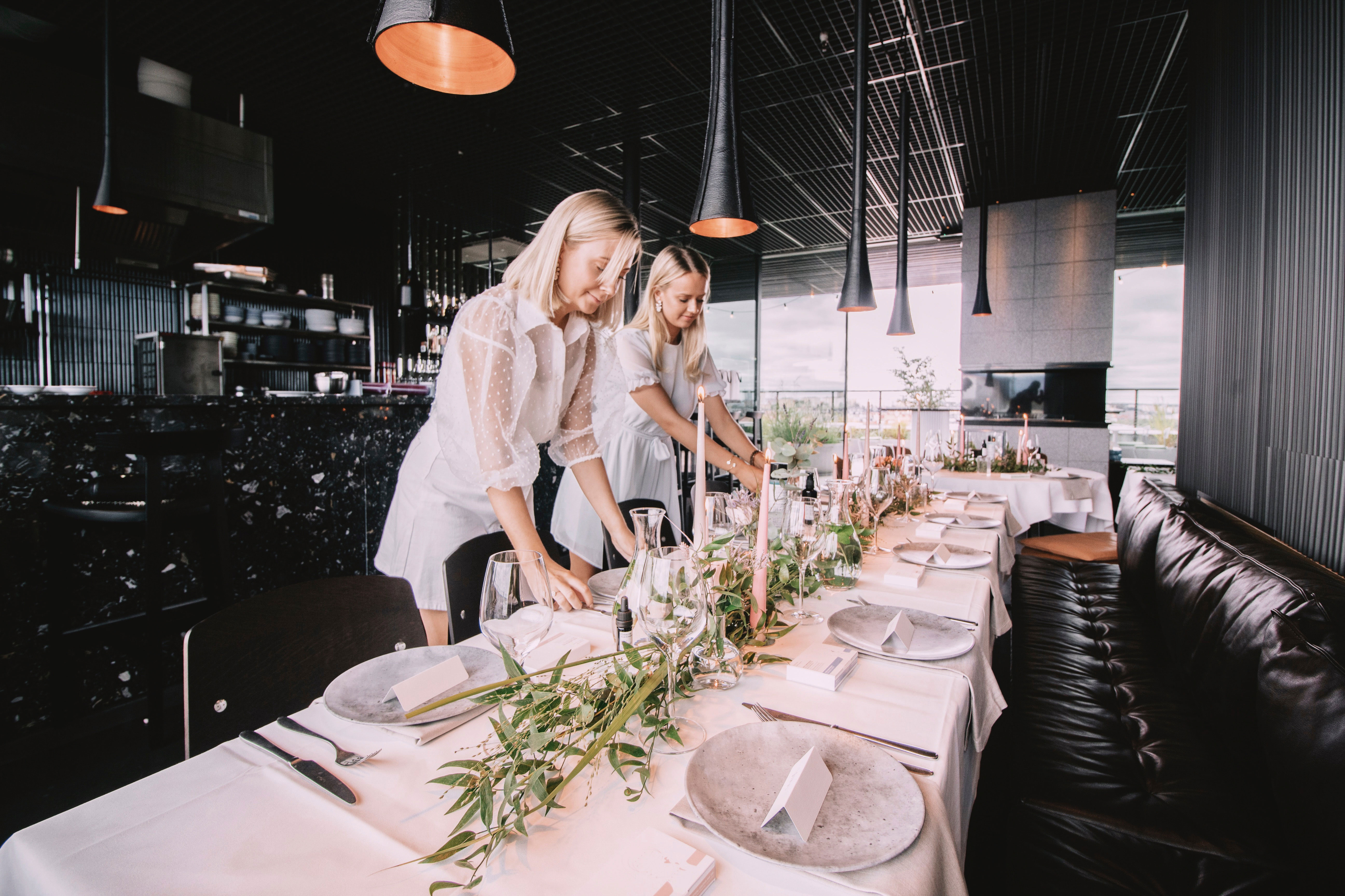 Två tjejer dukar ett långbord.