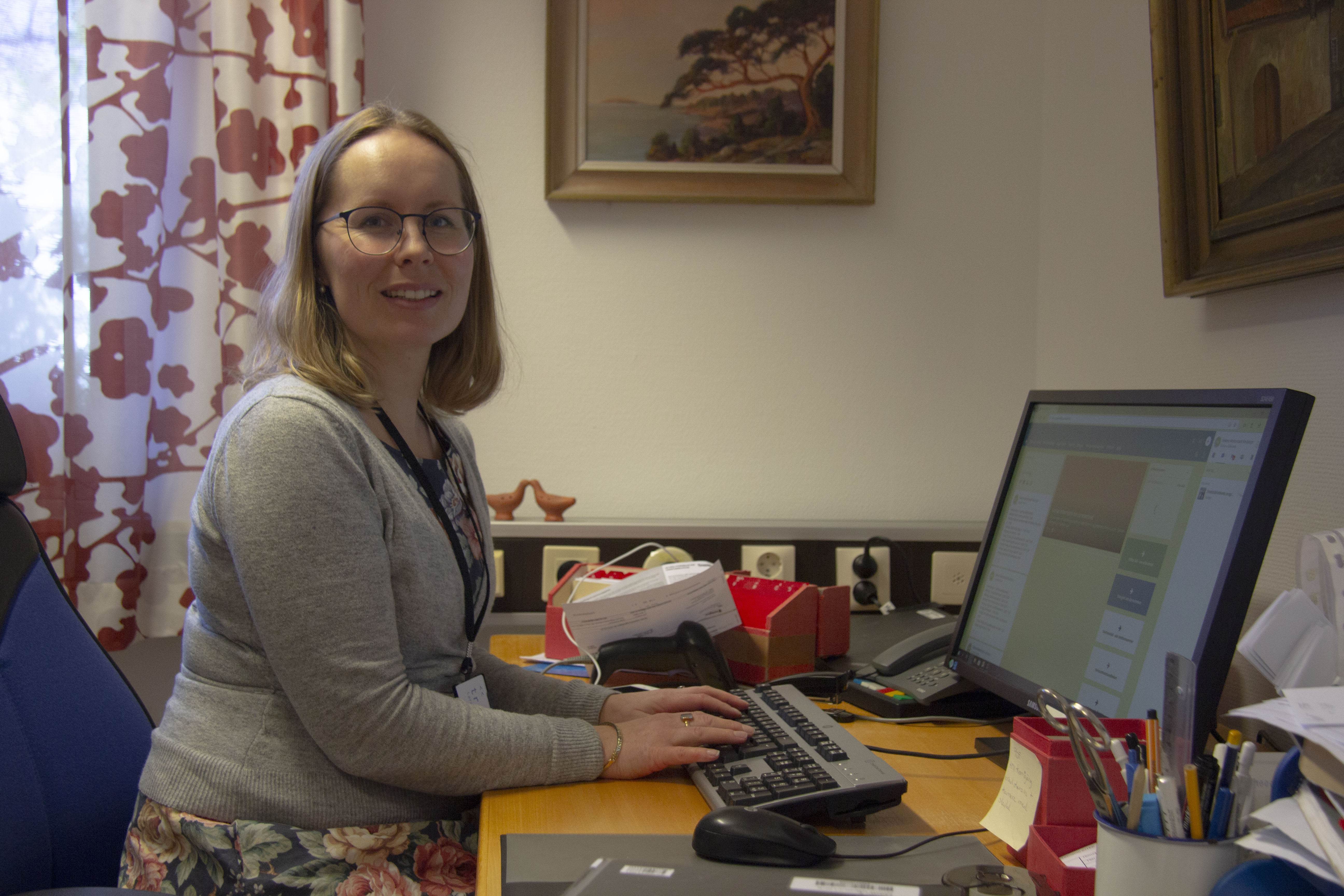 Helena sitter vid sitt skrivbord.