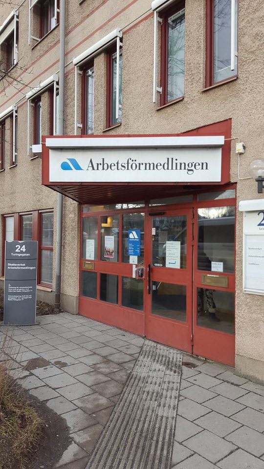 Utanför ett av arbetsförmedlingens kontor med deras logga i fokus.