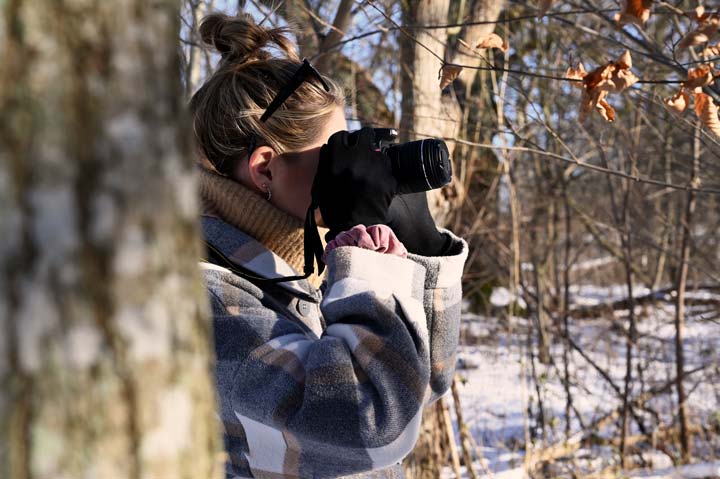 Bild på intervjupersonen som fotar en bild i skogen