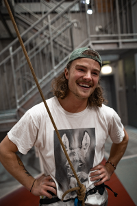 Hampus är fastspänd i klätterutrustning och ler stort.