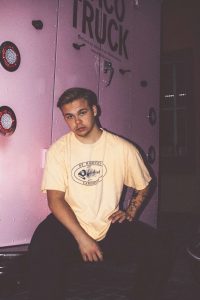 Oscar sitter i ett rum med lila ljus.