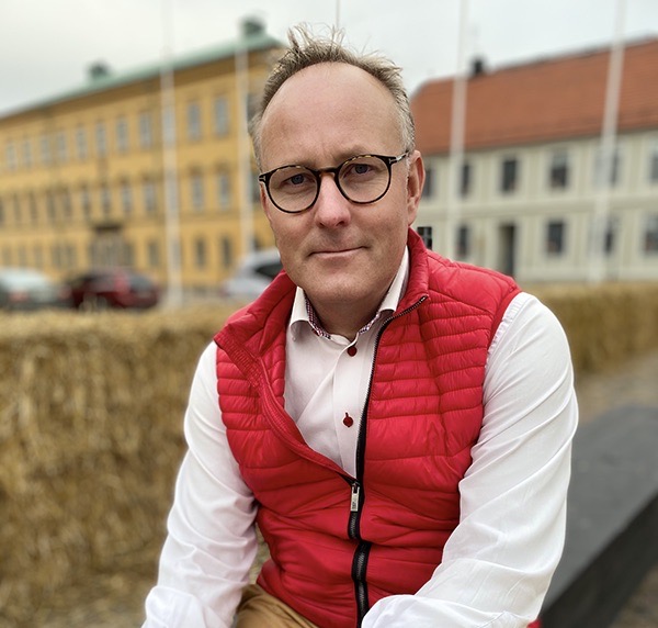 Johan Persson (S) sitter på Kalmars torg och ler in i kameran.