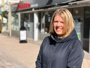 Lisa Söderholm står framför hennes kontor och ler in i kameran.