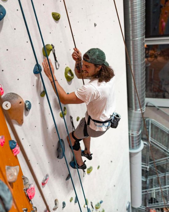 Hampus klättrar glatt på klätterväggen. 