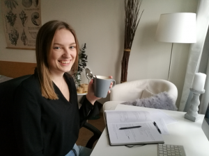 Viktoria Atladottír sitter med en kaffekopp vid sitt skrivbord.