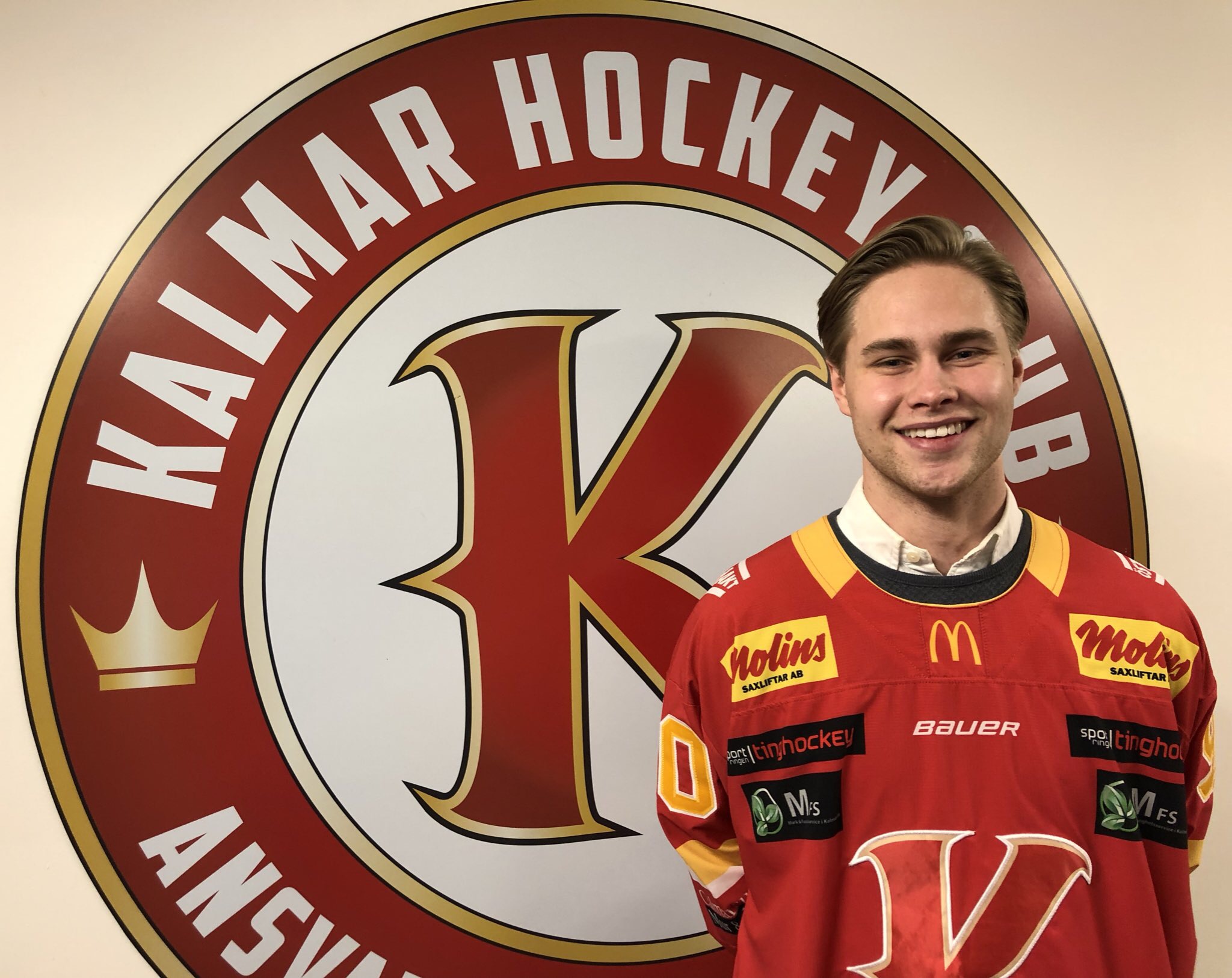 Nyförvärvet Johan Järlefelt står med sin nya matchtröja framför Kalmar HC:s logga