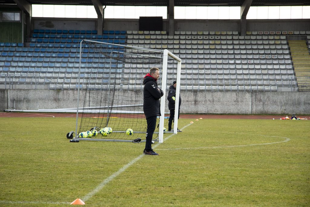 Tränaren står med på planen