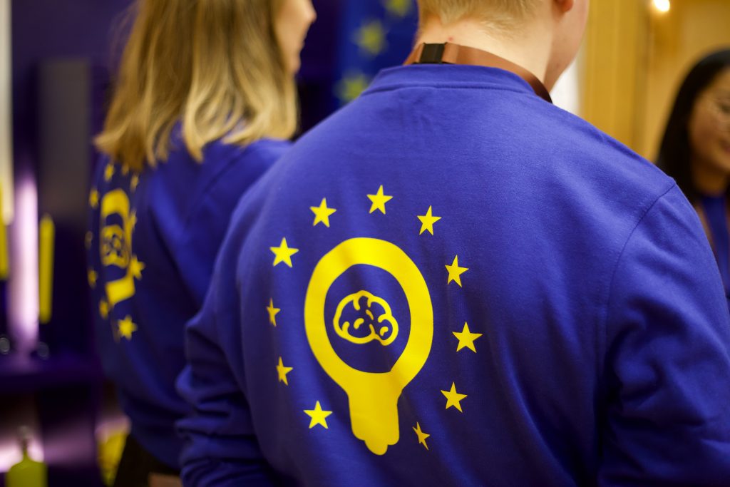 En pojke iförd en blå tröja med EU Knowledges logotyp