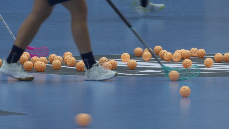 blått golv, massa bandybollar samt någons ben