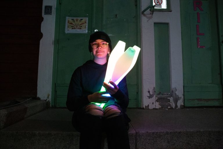 Desiré Follin sitter i en trapp med jongleringskäglor i händerna.