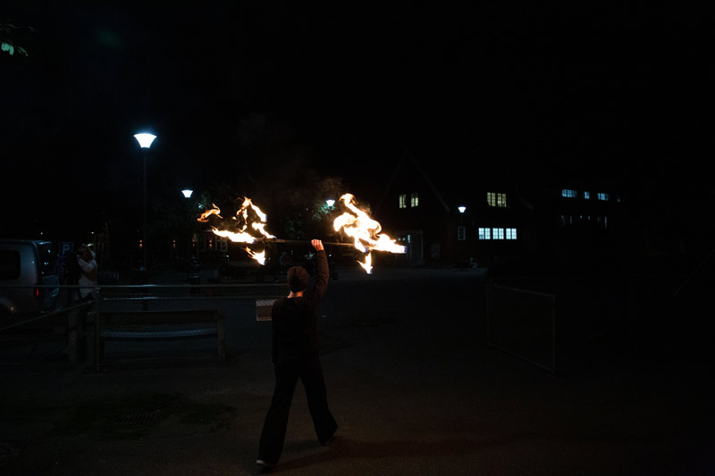 Tjej går med eldfackla ovanför huvudet.