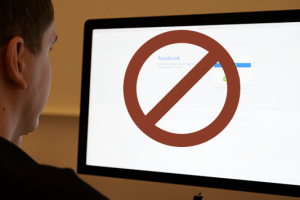 Facebook på dator med förbudsskylt.