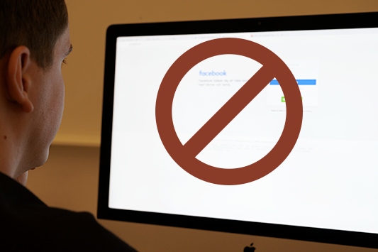 Facebook på dator med förbudsskylt.