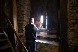 Donald Olsson kollar ut genom ett litet fönster i klocktornet på Kalmar domkyrka.