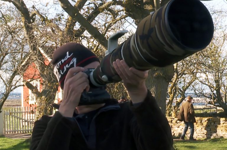Fågelskådare tittar in i en stor kikare