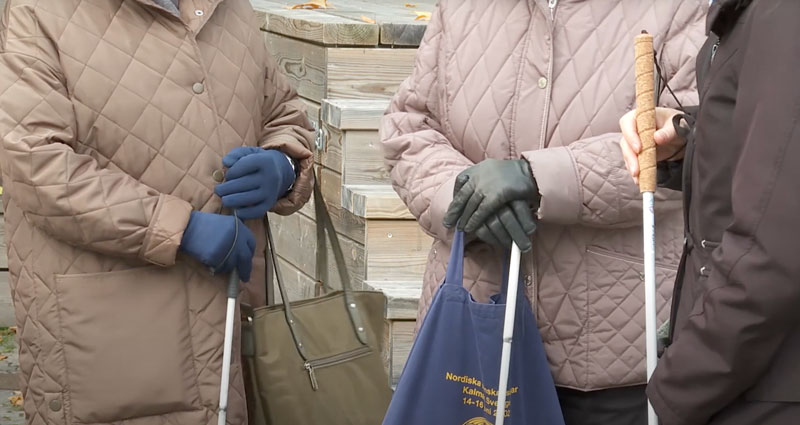 Tre kvinnor som håller i en varsin vit käpp