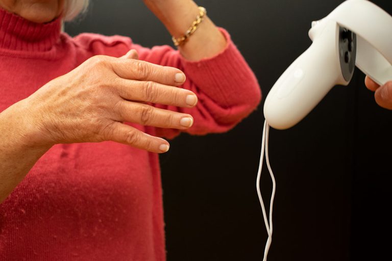 Äldre dam tar VR handkontrollen