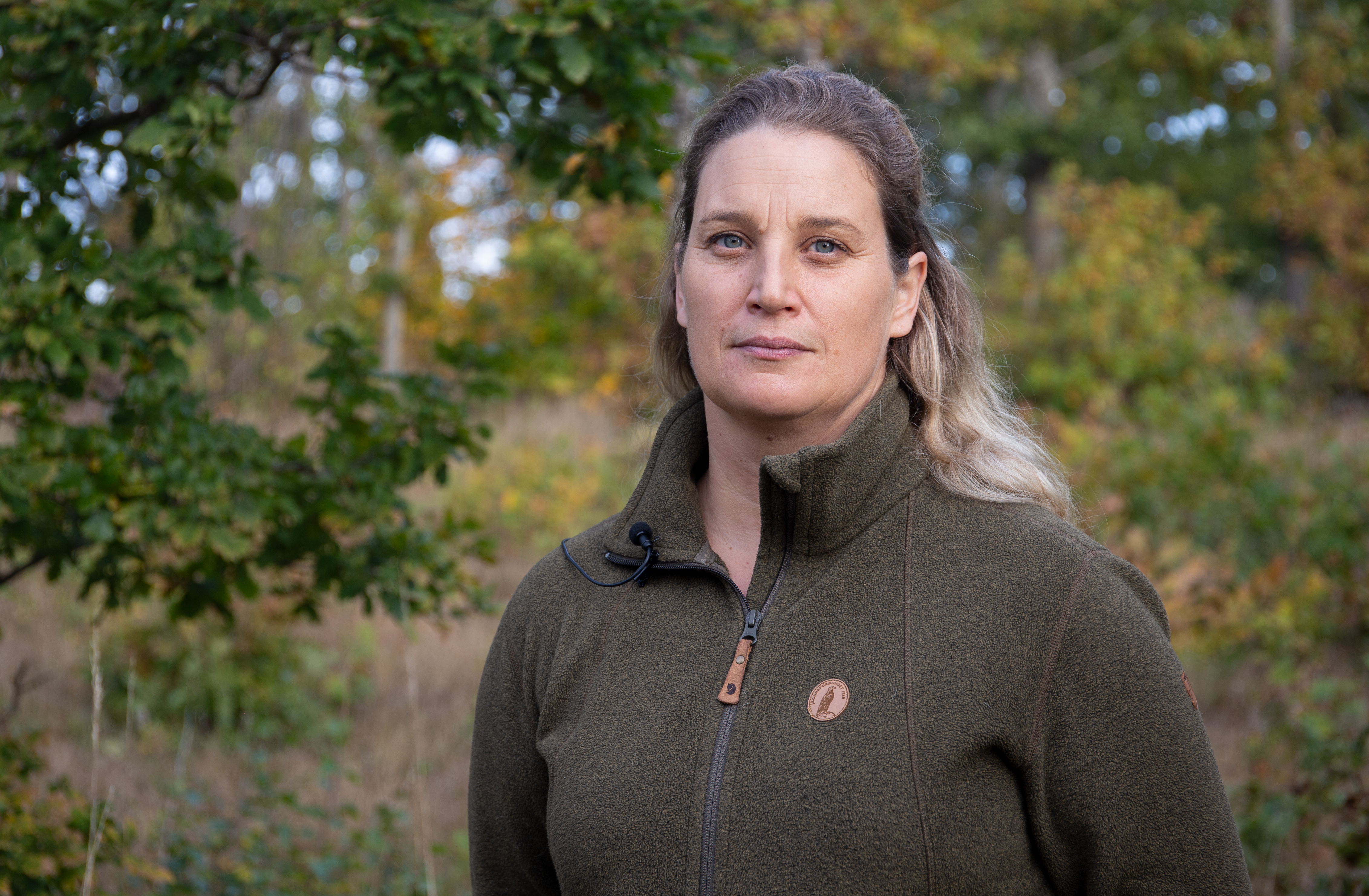Karin Stoeckmann poserar framför kameran ute i skogen