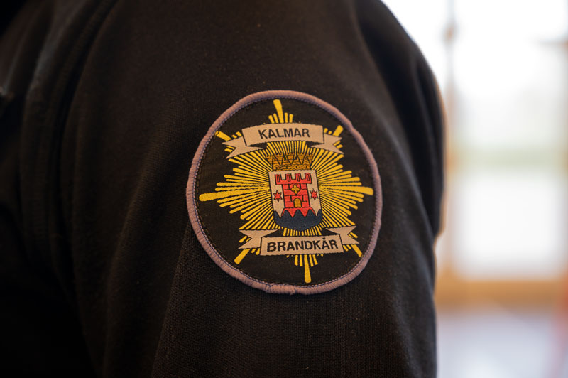 Närbild på överarmen på Kalle Daleen. På armen sitter Kalmar bbrandkårsomblev broderat.