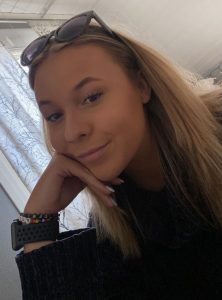 Elsa sitter och ler mot kameran.