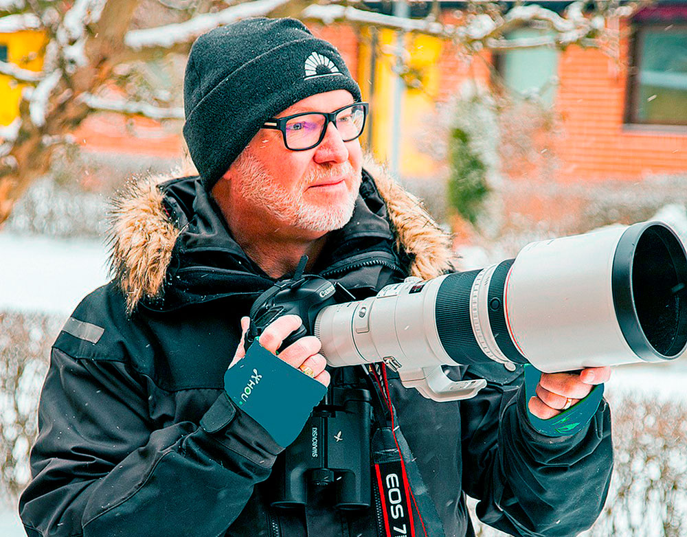 Bild på Thomas Johnsson i vinterkläder med en stor kamera i handen.