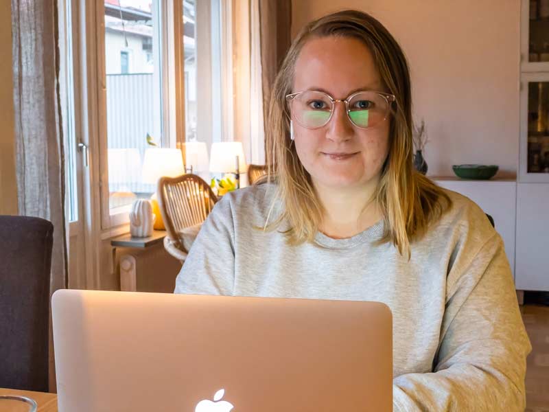 Jonna sitter vid sin dator vid köksbordet