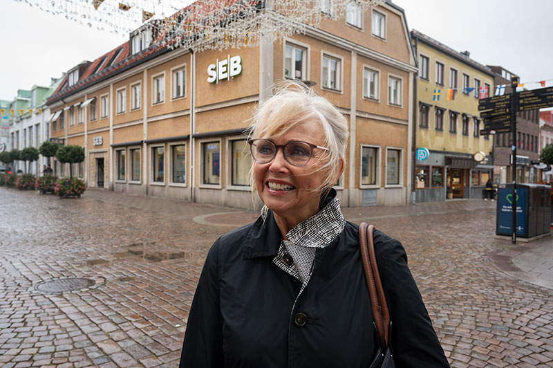 Porträtt av en glad kvinna på stan i ett regnig Kalmar