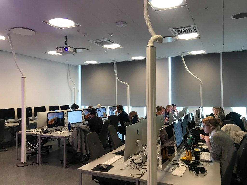 Studenter vid universitet sitter i en datorsal.