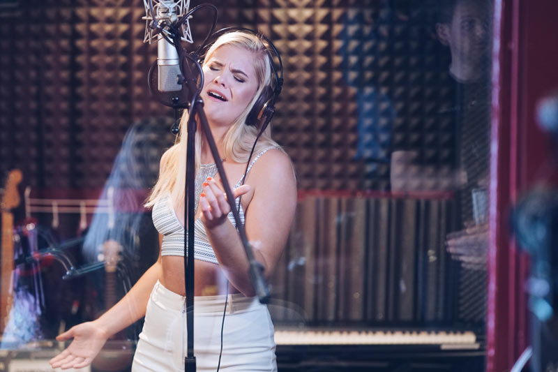 Kvinna sjunger i musikstudio. Foto: Anders Nordquist